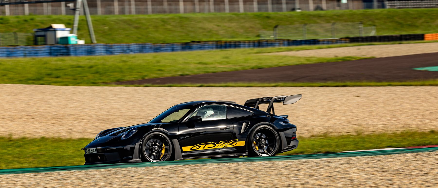 Schwarzer Porsche 911 GT3 RS in schneller Fahrt auf einer Rennstrecke