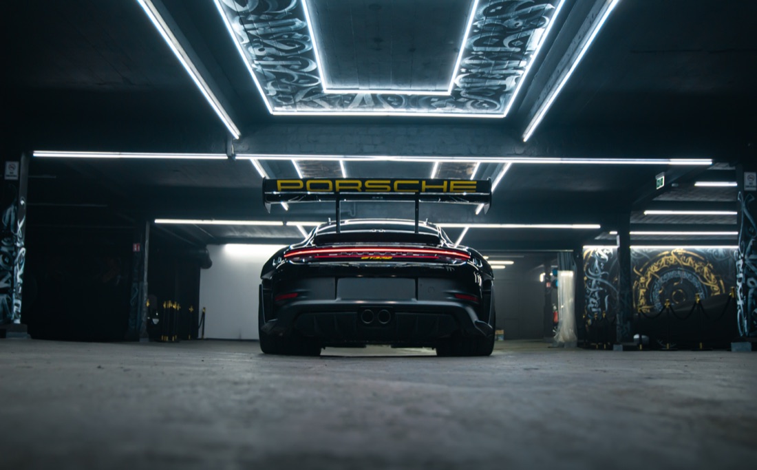 Porsche 911 GT3 RS von hinten aus tiefer Perspektive unter LED-Deckenrahmen