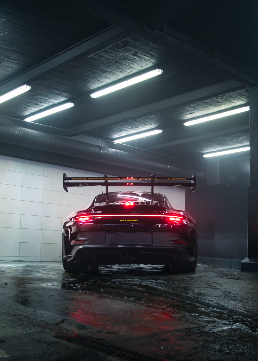 Porsche 911 GT3 RS von hinten in einer Waschhalle mit nassem Boden