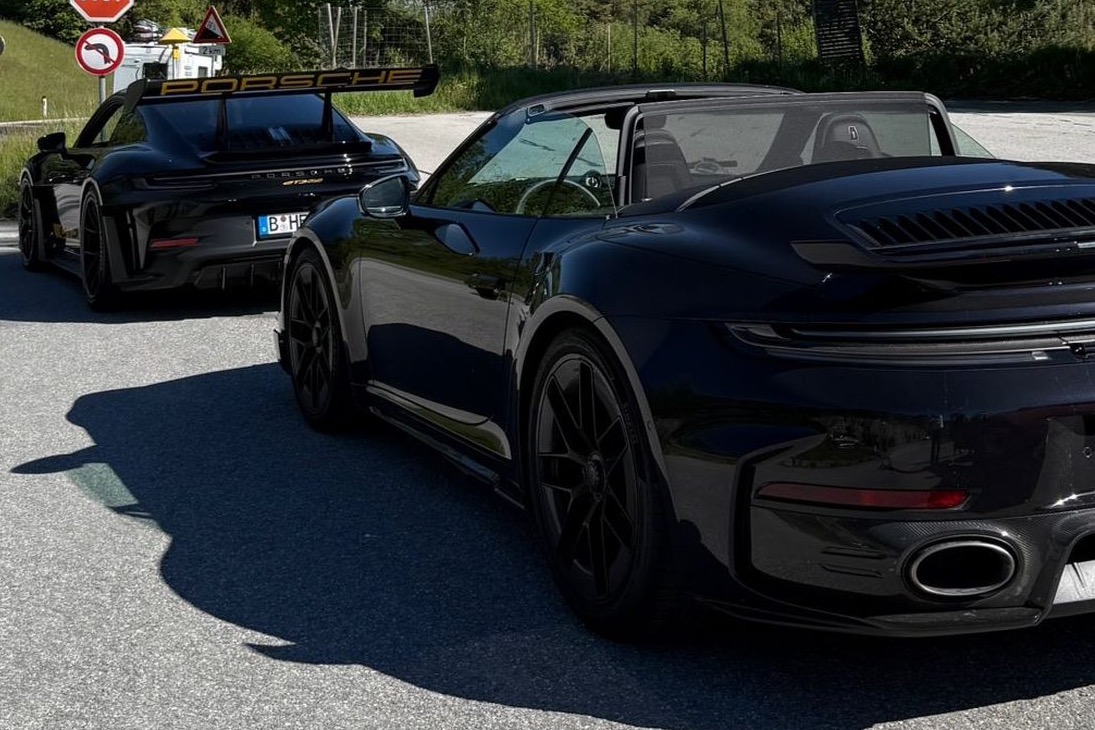 Porsche 911 Turbo S Cabriolet mit geöffnetem Verdeck auf einer Passstraße, dahinter der GT3 RS
