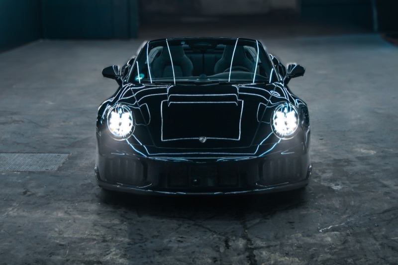 Porsche 911 Turbo S Cabriolet frontal mit geöffnetem Verdeck und eingeschalteten Scheinwerfern