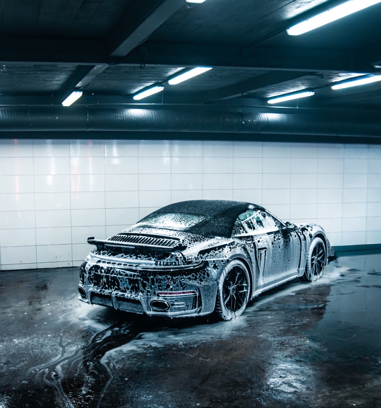 Porsche 911 Turbo S Cabriolet mit geschlossenem Verdeck, schaumbedeckt in einer Waschhalle